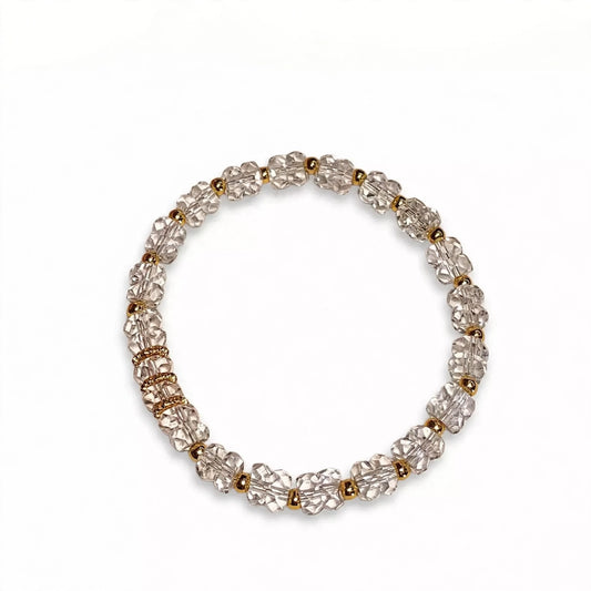 Clear crystal bracelet with gold spacers on white background