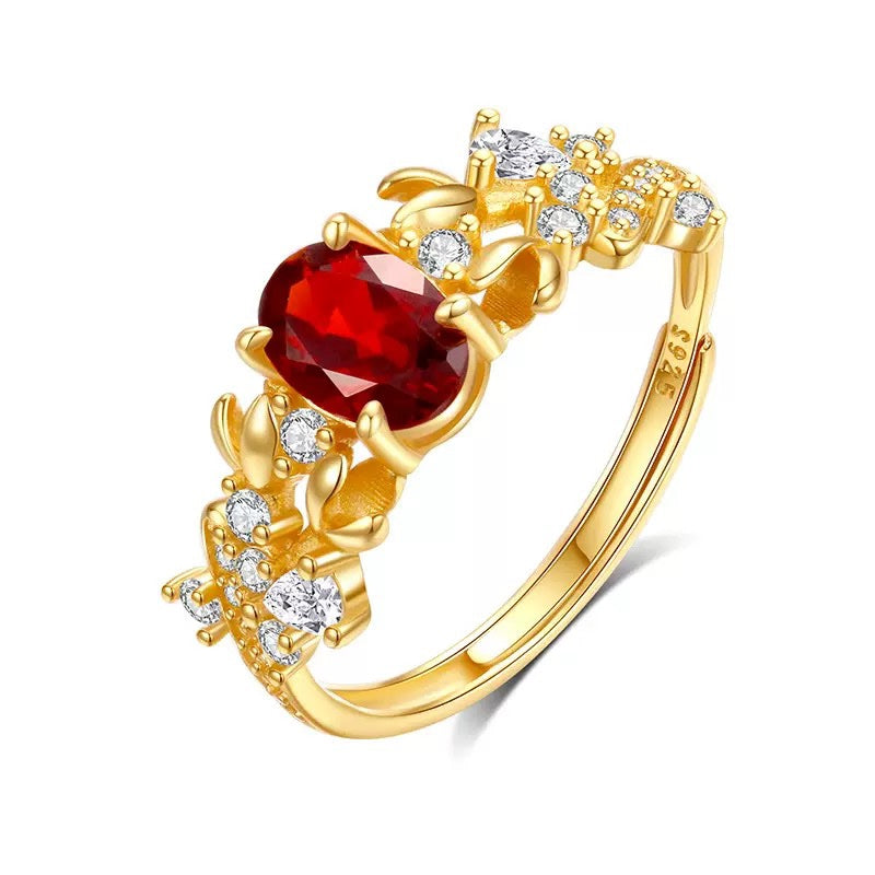 Bauhinia ring with garnet stone on white background